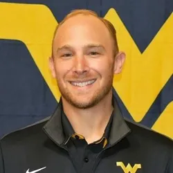 Photo of smiling man wearing a dark blue WVU shirt.