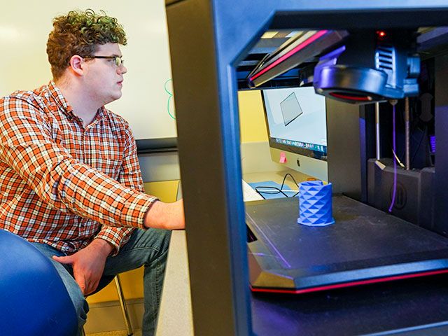 A student uses a computer to 3d print a tool for classrooms
