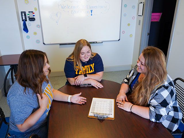 Students discuss scheduling options with a counselor in one of Allen Hall's meeting rooms