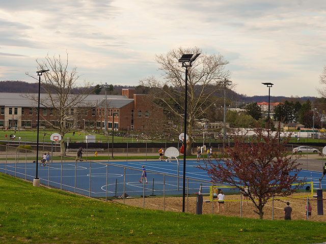 Students play on the Basketball and Volleyball courts outside of Allen Hall